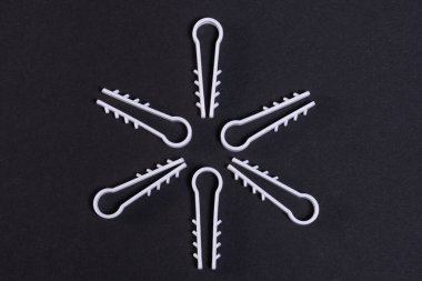 Tadilat sırasında duvara elektrik kablosu monte etmek için plastik klipler, siyah arka planda bir yıldız şeklinde dizilmiştir. 