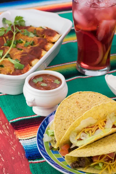 Mesa de fiestas mexicanas.Tacos, enchiladas, salsa y vaso de sangría — Foto de Stock