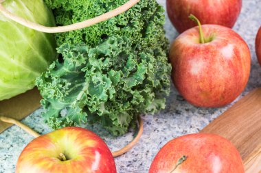 Çiftlik organik elma, kale ve mutfak masasının üzerinde yeşil lahana.