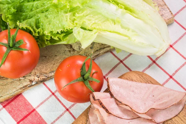 Ingrediënten voor sandwich - tomaten, sla en stukjes ham. — Stockfoto