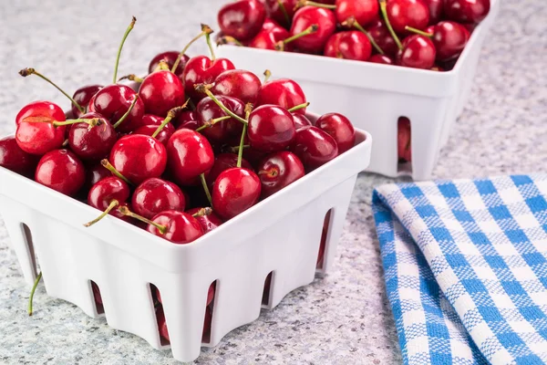 Siebe mit roten Bio-Kirschen auf dem Küchentisch. — Stockfoto