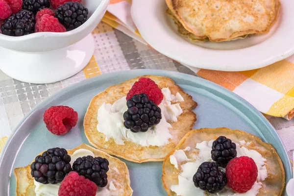 Cornmeal cakes garnish with fresh berries and bowl of berry fig