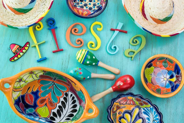 Mexican fiesta table decoration with  colorful painted letters, sombreros, bright pottery.