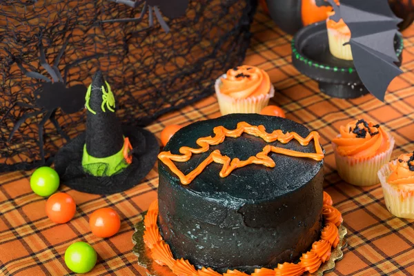 Хэллоуинский торт с маслом и кексы . — стоковое фото