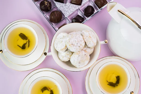 Xícaras de chá com chá verde, biscoitos e doces de chocolate . — Fotografia de Stock