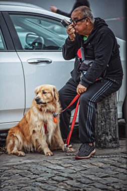 Sokakta köpeği olan, tanınmayan yaşlı bir adam.