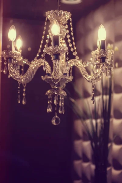 vintage light bulb on a background of the fireplace, the lights of the garland, the chandelier.