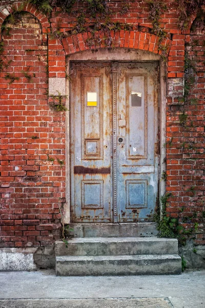 赤いレンガの壁を持つ古い木製のドア — ストック写真