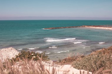 Deniz dalgaları ve mavi gökyüzü olan güzel sahil
