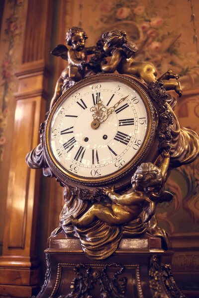 old vintage clock on the background of the antique wall