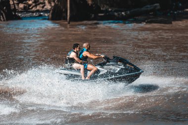 Su bisikleti süren iki kişi.