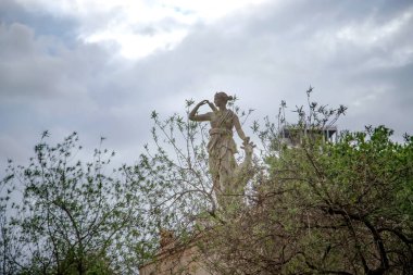 Yeşil ağaçlarla çevrili heykel