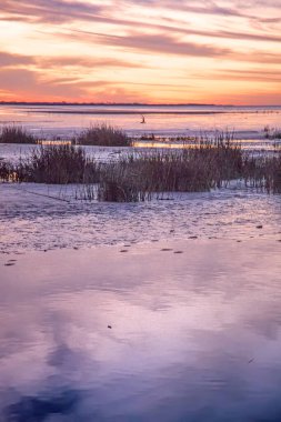 Calm water reflecting colorful sunset sky