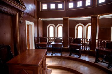 Büyük pencereli ahşap mahkeme salonu.