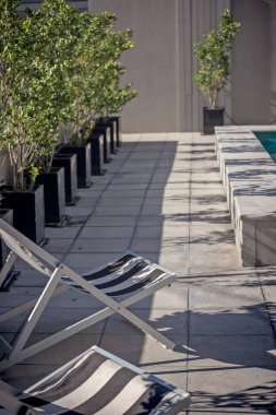 Yüzme havuzunun yanında bir çift plaj sandalyesi.