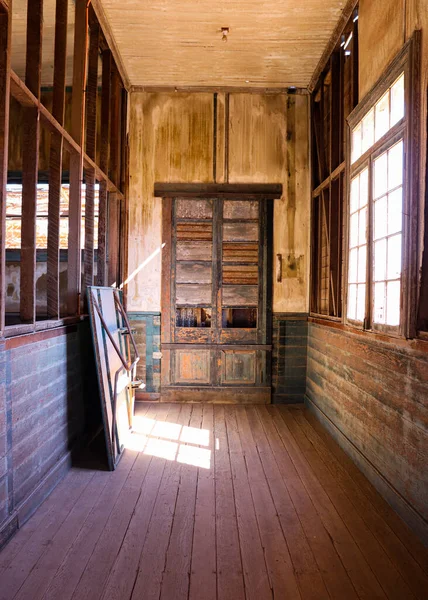 Terk edilmiş bir okulda eski ahşap bir kapı. 