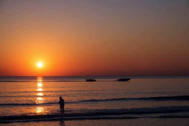 Siluet kişi ile plajda gün batımı görünümü