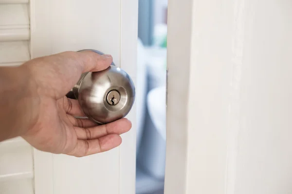 Bouton de porte à main fermé, ouverture légère, mise au point sélective — Photo