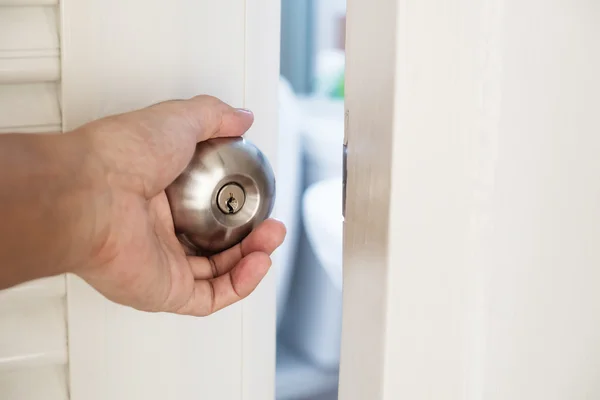 Bouton de porte à main fermé, ouverture légère, mise au point sélective — Photo