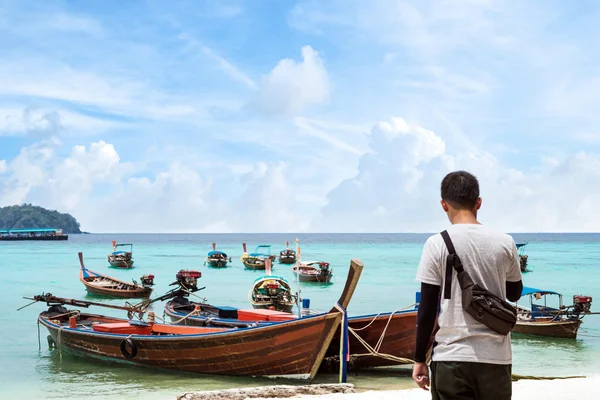 Ázsiai pasas állva a strandon csónakok Lipe island, Thaiföld, reggel — Stock Fotó