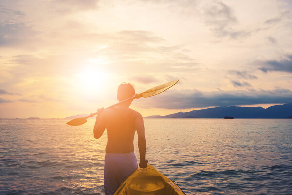 a guy pulling kayak to the sea in sunset, vacation holiday summertime concepts, vintage tone
