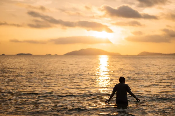 Silhouette woman walking in the sea in sunset — Stock Photo, Image