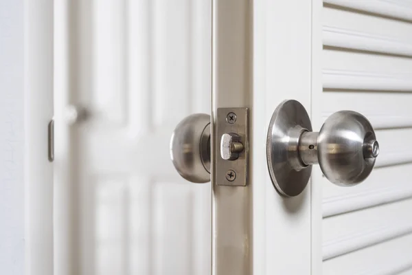 Fechar a maçaneta da porta inoxidável, com a porta ligeiramente aberta — Fotografia de Stock