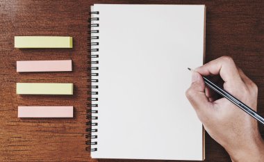 Defter ahşap masanın üzerinde vintage sesi yazılı kalem tutan el