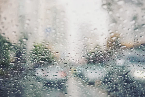 Raindrops on car's wind shield on the street, selective focus, shallow depth of field — Stock Photo, Image