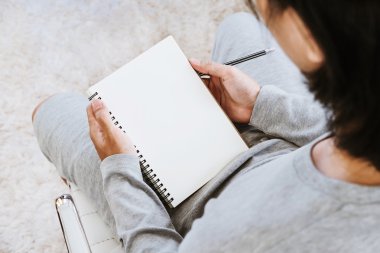 Boş defter kalem oturma odasında ile Asya adam