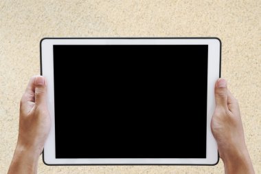 Dijital tablet ekranında, kopya alanı ile kum doku arka planda tutan el