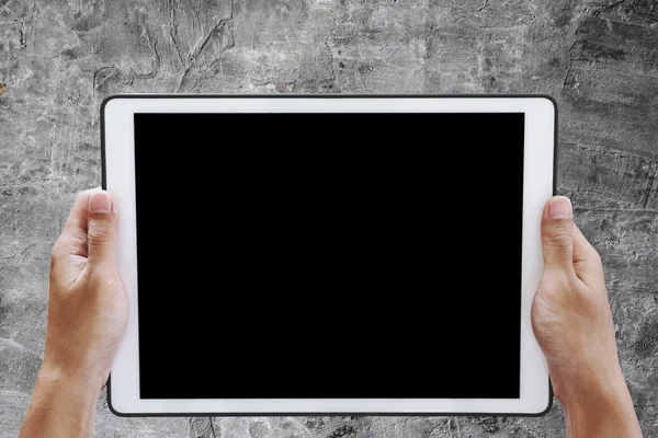 Hand holding digital tablet, with copy space on screen, on concrete texture background — Stock Photo, Image