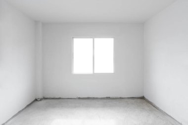 Beton zemin, beyaz duvar ve pencereli. İnşaat odasının içi boş.