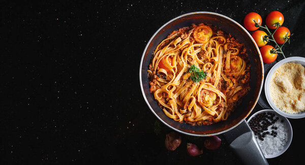 Pasta Bolognese in frying pan with fresh ingredient. Top View