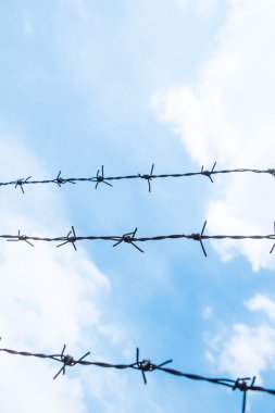 Alan sığ derinliği, eski mavi gökyüzü karşı çelik tel dikenli.
