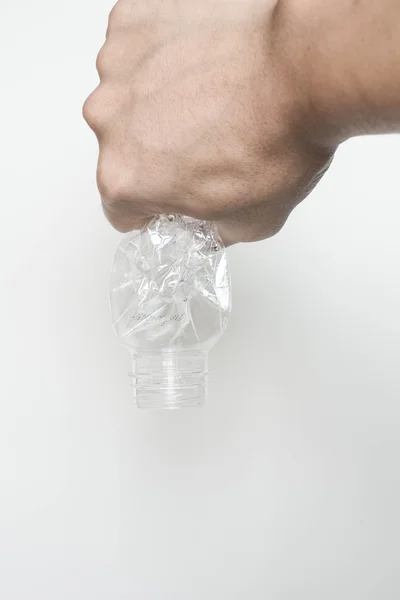 Männliche Hand drückt und gießt Plastikflasche herunter — Stockfoto