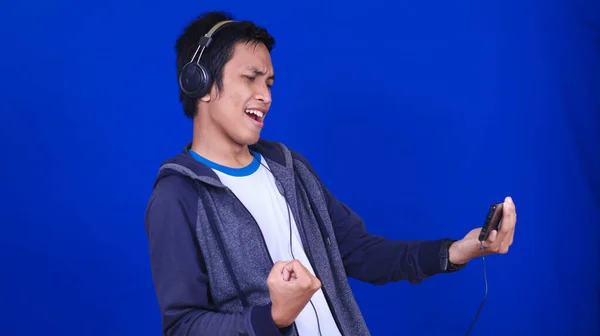Азиатский Человек Играет Мобильную Игру Счастливым Выражением Изолированный Синий Фон — стоковое фото