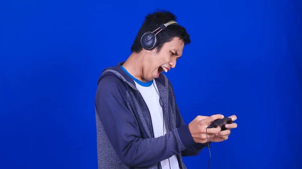 Asiatico Uomo Giocare Mobile Gioco Con Felice Espressione Isolato Blu — Foto Stock