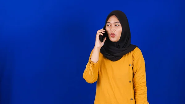 Ásia Hijab Mulher Vestindo Máscara Chamando Amigo Isolado Azul Fundo — Fotografia de Stock