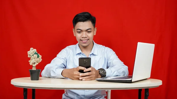 Junge Asiatische Geschäftsmann Lächelnd Sehen Handtelefon Mit Laptop Auf Tisch — Stockfoto