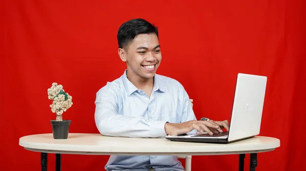亚洲商人与笔记本电脑隔离的红色背景 — 图库照片