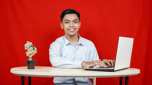 亚洲商人与笔记本电脑隔离的红色背景 — 图库照片