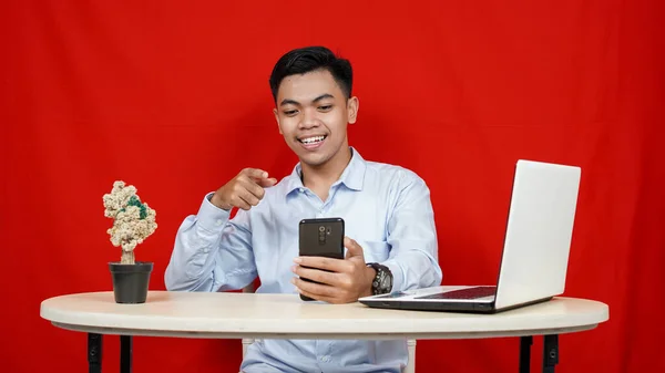 Young Asian Business Man Pointing Handphone Isolated Red Background — Stock Photo, Image