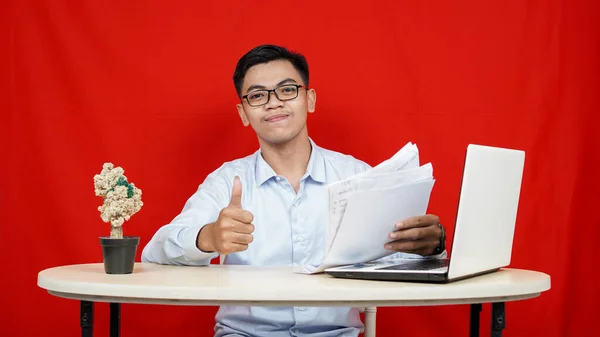 亚洲商人好吗手势和笔记本电脑放在桌上孤立的红色背景 — 图库照片