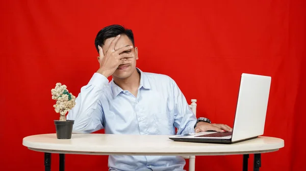 Молодой Азиатский Бизнесмен Скрывает Свое Лицо Рукой Ноутбука Изолированный Красный — стоковое фото