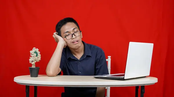 Genç Asyalı Adamı Çalışma Alanında Uykulu Kırmızı Arka Planda — Stok fotoğraf