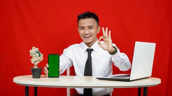 Νεαρός Ασιάτης Επιχειρηματίας Δείχνει Κινητό Τηλέφωνο Πράσινη Οθόνη Απομονωμένο Κόκκινο — Φωτογραφία Αρχείου