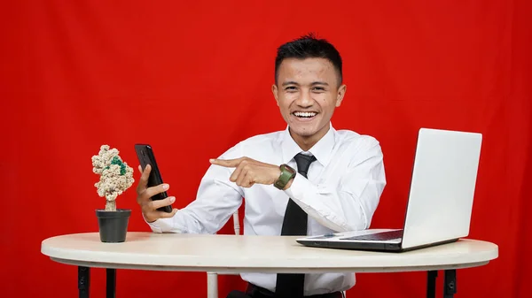Mladý Asijské Obchod Muž Ukazující Ruční Telefon Izolované Červené Pozadí — Stock fotografie
