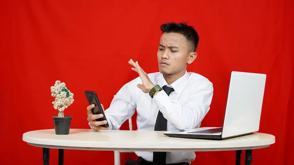Genç Asyalı Adamı Elini Cep Telefonundan Laptoptan Gizliyor Kırmızı Arka — Stok fotoğraf