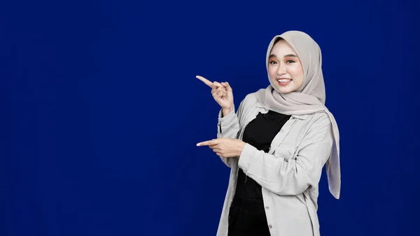 Aziatisch Hijab Vrouw Wijzend Links Lege Ruimte Geïsoleerde Blauw Achtergrond — Stockfoto